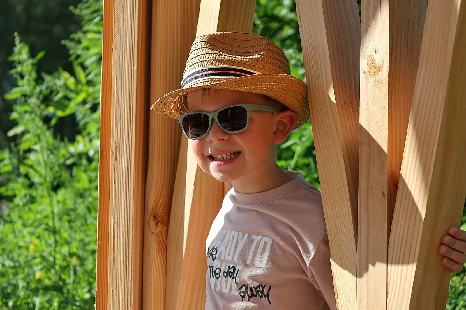 Portrait joyeux d'un jeune garçon en chapeau de paille et lunettes de soleil.